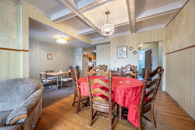 dining area with wallpapered walls, an inviting chandelier, light wood-type flooring, and coffered ceiling