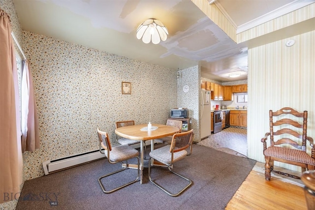 dining area featuring a baseboard radiator, light wood-style flooring, crown molding, and wallpapered walls