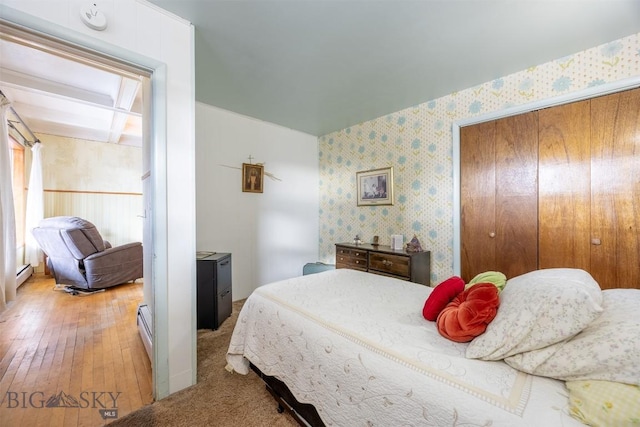 bedroom featuring wallpapered walls, a closet, and a baseboard radiator