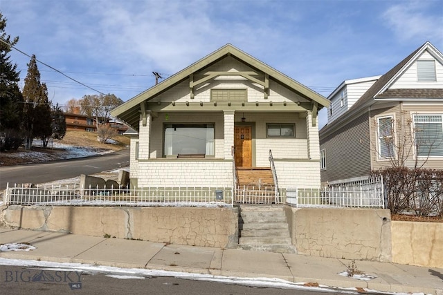 view of front of house with a fenced front yard and a porch