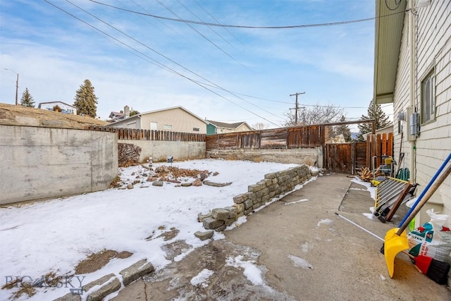 yard layered in snow featuring a fenced backyard