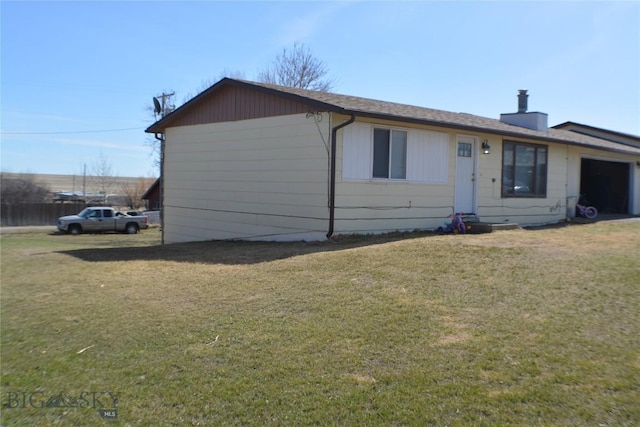 view of front of house featuring a garage, a chimney, and a front yard