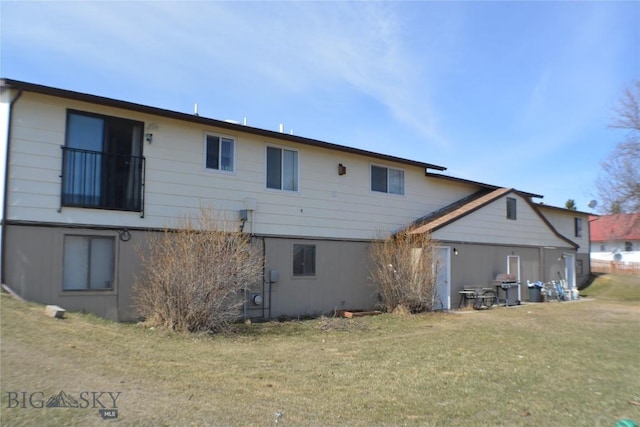 back of house with a lawn