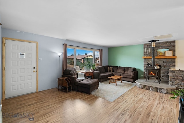 living area with a wood stove and wood finished floors