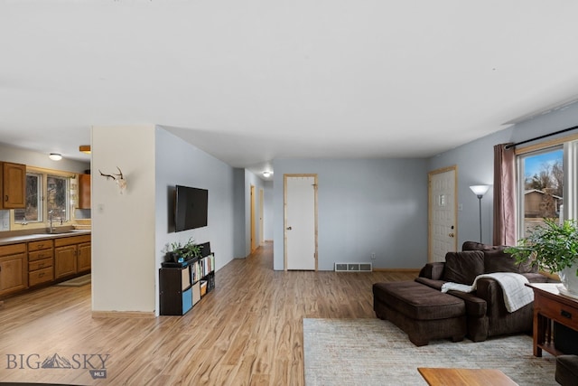 living room featuring light wood finished floors and visible vents