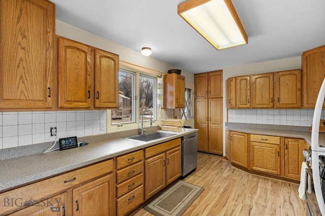 kitchen featuring tasteful backsplash, dishwasher, light wood-type flooring, brown cabinetry, and a sink