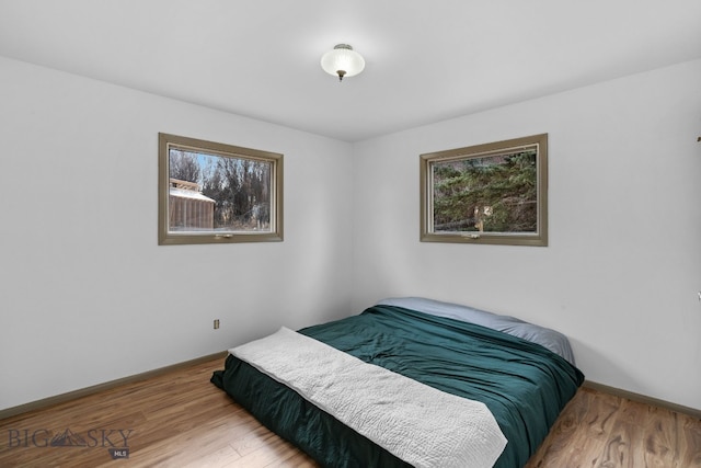 bedroom with baseboards and wood finished floors