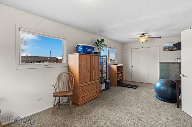 interior space featuring carpet flooring, a ceiling fan, visible vents, and a textured ceiling