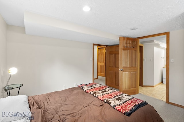 bedroom with carpet flooring, a textured ceiling, and baseboards