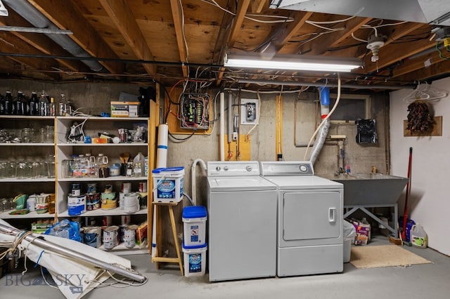 washroom featuring washer and clothes dryer, laundry area, and a sink