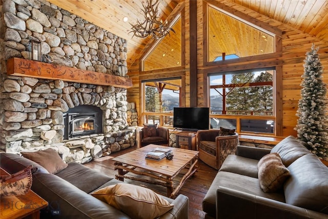 living area featuring wooden walls, wooden ceiling, a stone fireplace, and hardwood / wood-style flooring