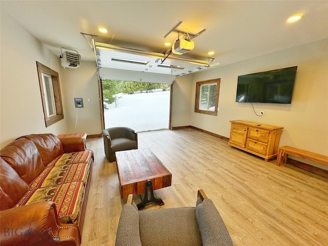 living room with baseboards, light wood-type flooring, and a garage