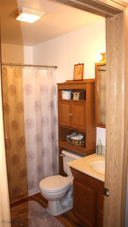 full bathroom with curtained shower, toilet, wood finished floors, and vanity