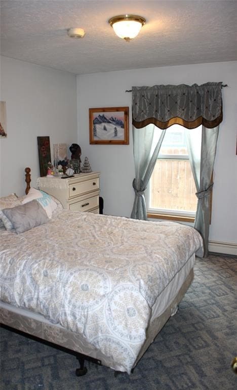 carpeted bedroom featuring a baseboard radiator and a textured ceiling