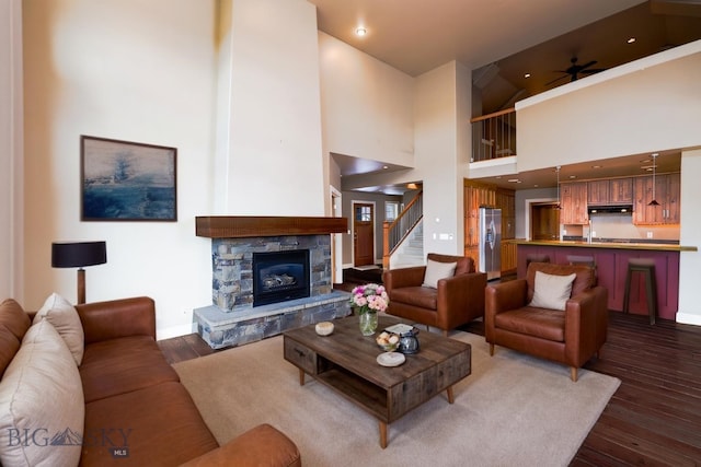 284 Annie Glade, Bozeman, MT 59718 - living area featuring baseboards, ceiling fan, dark wood-type flooring, stairway, and a fireplace