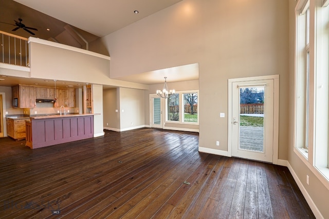 284 Annie Glade, Bozeman, MT 59718 - unfurnished living room with a high ceiling, a chandelier, dark wood-type flooring, baseboards, and a sink