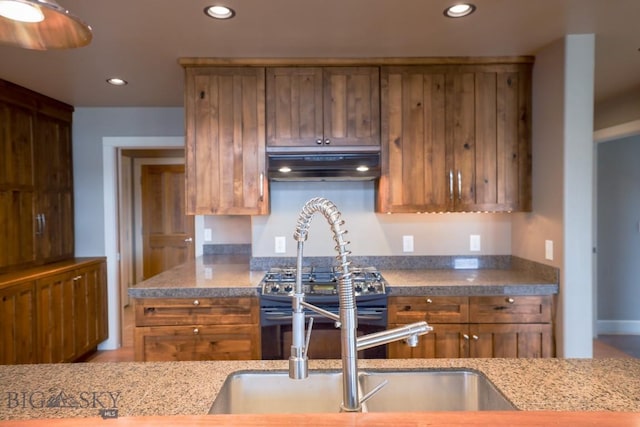 284 Annie Glade, Bozeman, MT 59718 - kitchen featuring under cabinet range hood, recessed lighting, brown cabinets, black gas range, and light stone counters