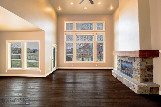 284 Annie Glade, Bozeman, MT 59718 - unfurnished living room with a fireplace, dark wood-style flooring, plenty of natural light, baseboards, and recessed lighting