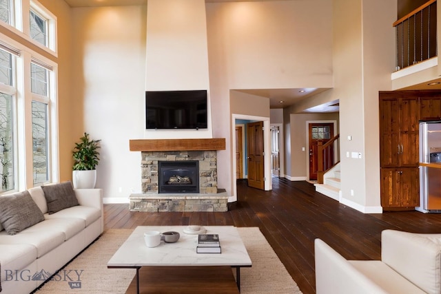 284 Annie Glade, Bozeman, MT 59718 - living area with a high ceiling, dark wood-type flooring, baseboards, stairway, and a stone fireplace