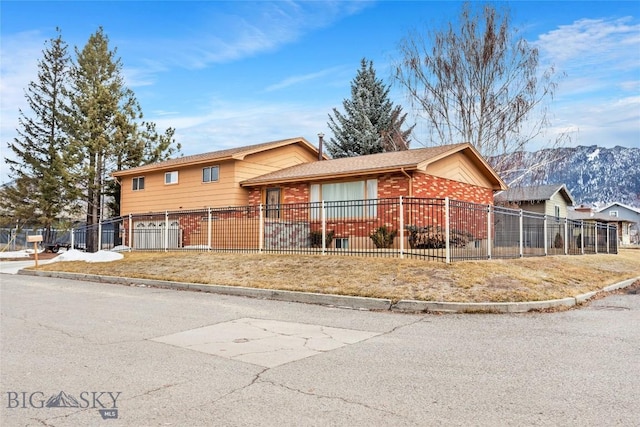 split level home with brick siding and a fenced front yard