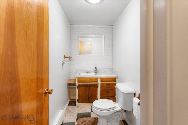 bathroom with toilet, baseboards, and vanity