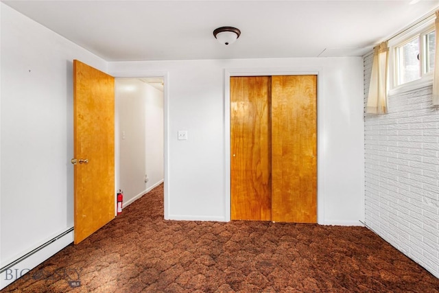 unfurnished bedroom featuring a closet, carpet flooring, baseboards, and a baseboard radiator