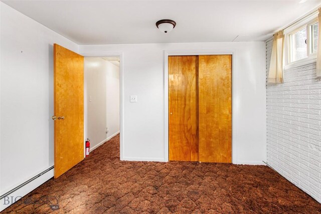 unfurnished bedroom with carpet floors, a closet, and a baseboard radiator