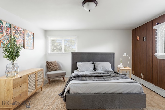bedroom with wooden walls and light carpet