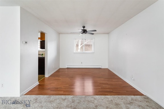 spare room with baseboards, wood finished floors, baseboard heating, and ceiling fan