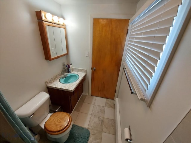 half bath featuring vanity, tile patterned flooring, and toilet