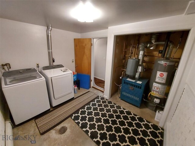 clothes washing area featuring a heating unit, laundry area, washing machine and dryer, and water heater