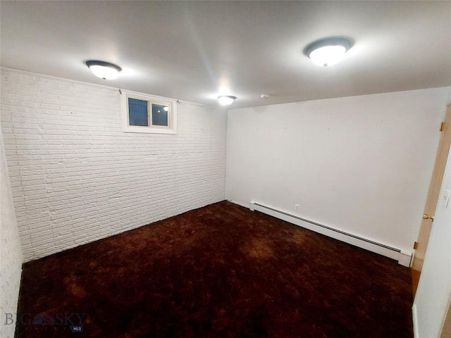 finished below grade area featuring a baseboard radiator, dark carpet, and brick wall