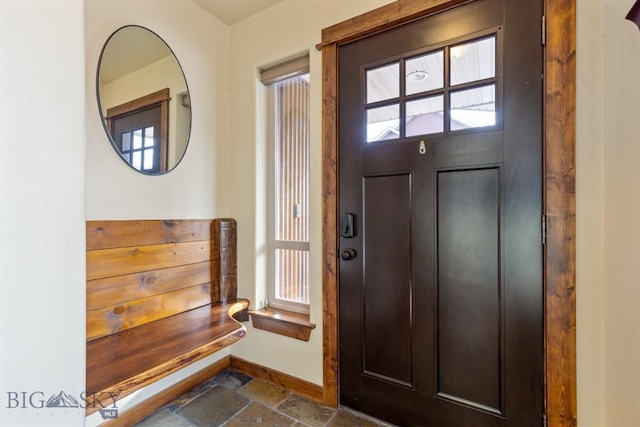 foyer entrance with stone tile floors and baseboards