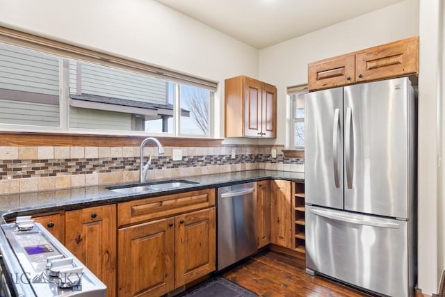 kitchen featuring brown cabinetry, tasteful backsplash, appliances with stainless steel finishes, and a sink