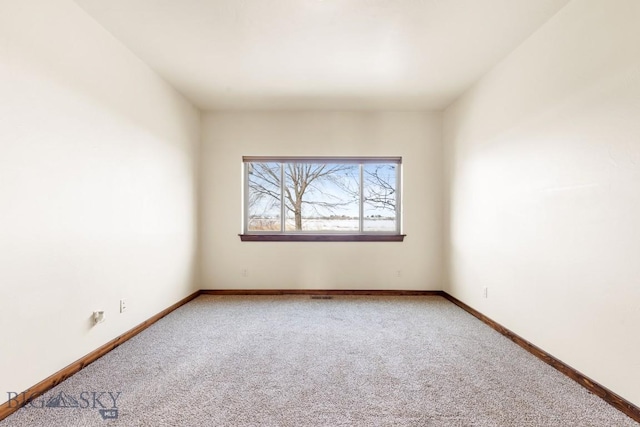 unfurnished room with light carpet and baseboards