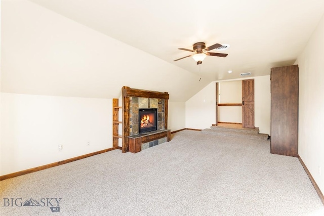 unfurnished living room featuring carpet, a ceiling fan, baseboards, lofted ceiling, and a fireplace