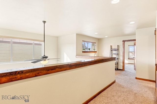 hallway featuring recessed lighting, baseboards, plenty of natural light, and light colored carpet