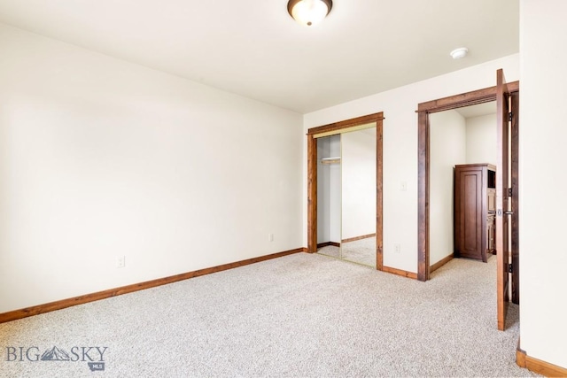 unfurnished bedroom featuring baseboards, light carpet, and a closet