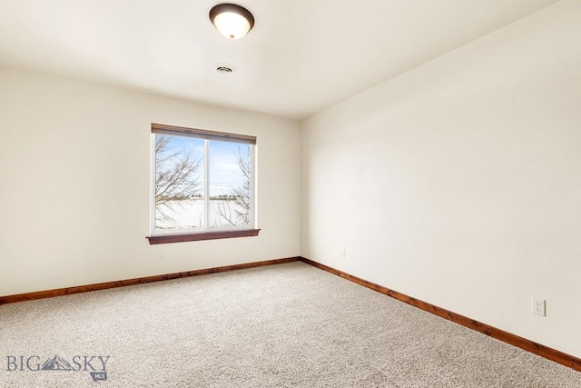 carpeted spare room featuring visible vents and baseboards