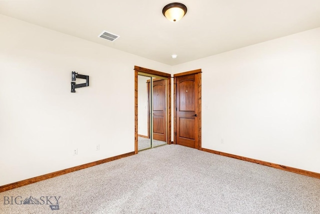 empty room with visible vents, baseboards, and carpet