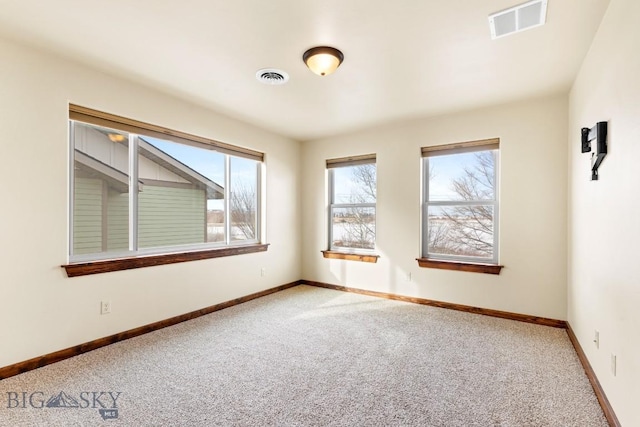 carpeted empty room featuring visible vents and baseboards