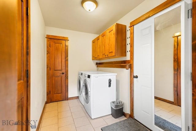 laundry area featuring baseboards, cabinet space, separate washer and dryer, and light tile patterned flooring