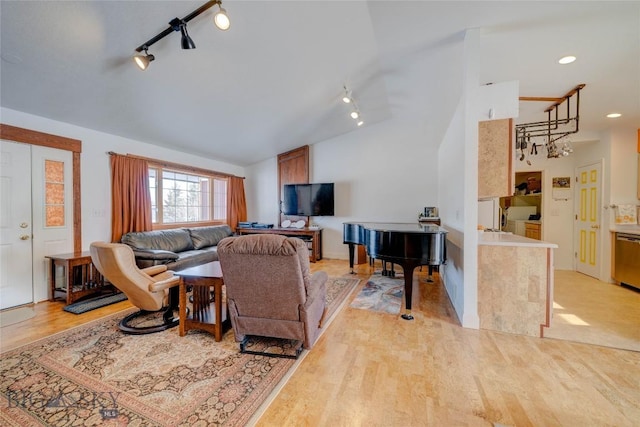 living area featuring track lighting, high vaulted ceiling, and light wood-style floors