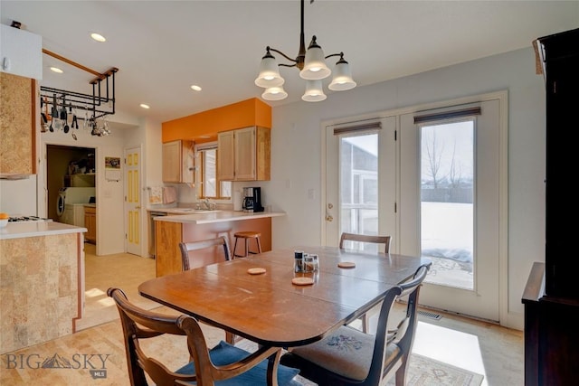 dining space featuring recessed lighting, an inviting chandelier, a healthy amount of sunlight, and washing machine and clothes dryer