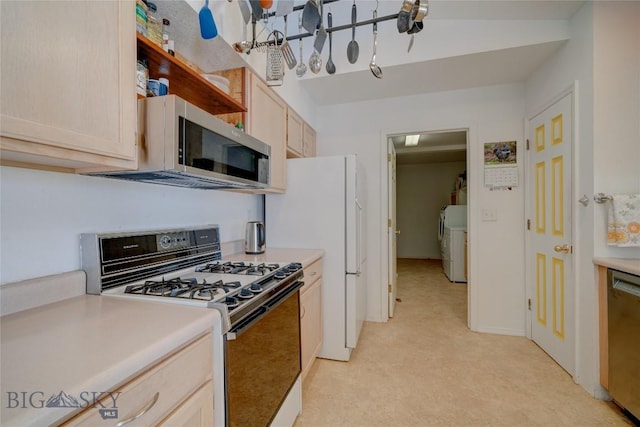 kitchen featuring washer and dryer, appliances with stainless steel finishes, light brown cabinetry, and light countertops