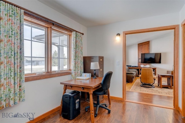 office space featuring baseboards and wood finished floors