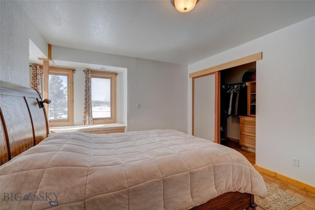 bedroom with a closet, baseboards, and wood finished floors