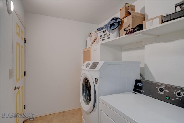 laundry area with baseboards, washing machine and dryer, and laundry area