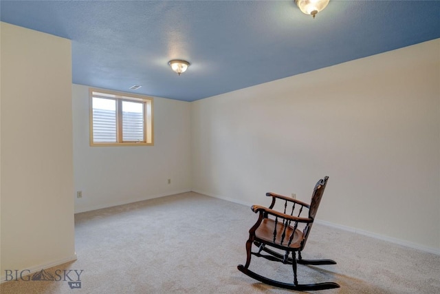 living area featuring baseboards, carpet floors, a textured ceiling, and visible vents