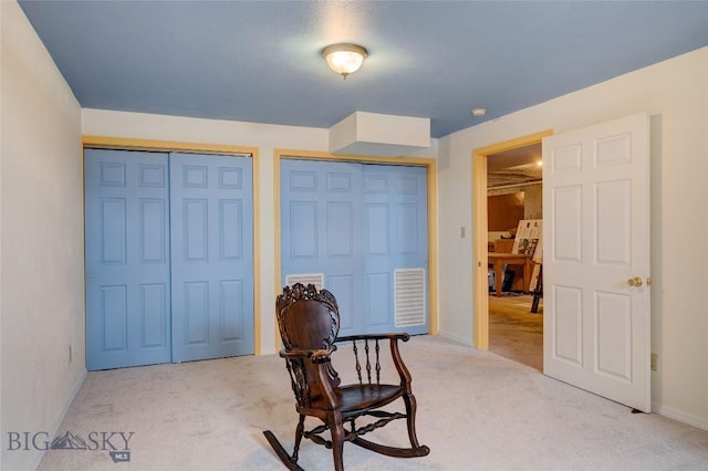 sitting room with carpet flooring, visible vents, and baseboards